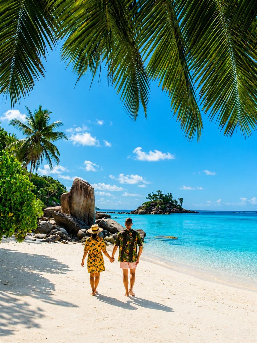 Casal caminhando na praia durante a viagem